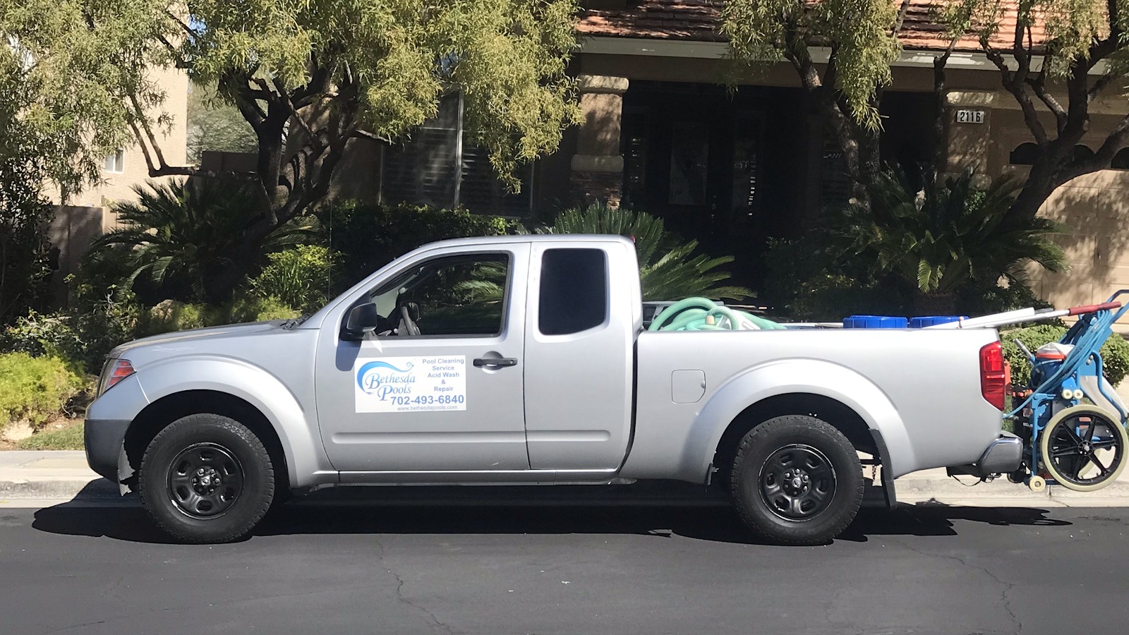 Silver Bethesda Pools Nissan Frontier truck with equipment in bed